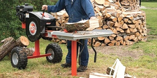 are electric log splitters any good - man using electric log splitter to split logs