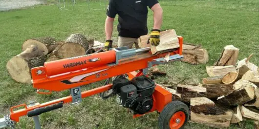are electric log splitters any good - man splitting logs using electric log splitter