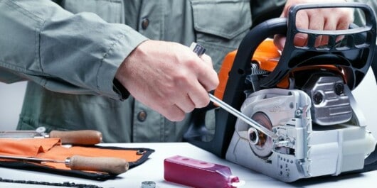 person disassembling chainsaw components