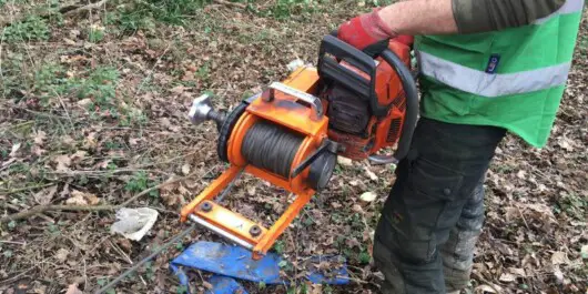 professional logger holding a chainsaw winch