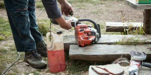professional logger putting oil on chainsaw