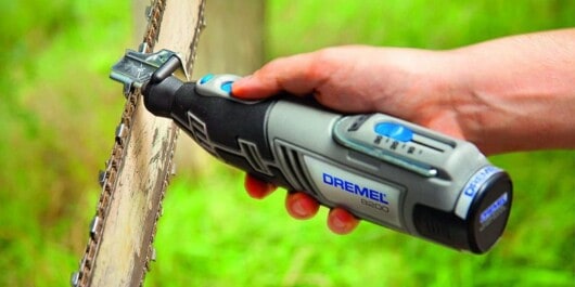 person using a dremel sharpener to sharpen the chainsaw chain