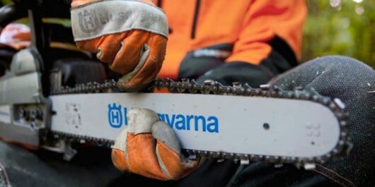 professional logger tightening the chain in the chainsaw