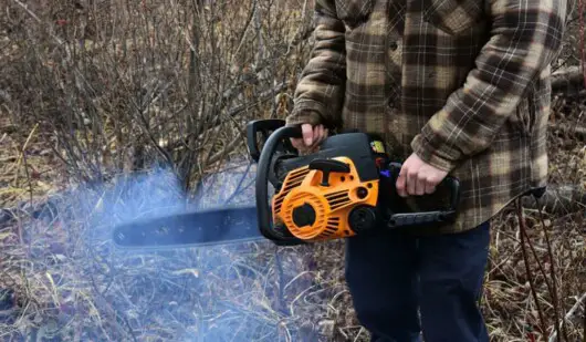 man holding a chainsaw smoking
