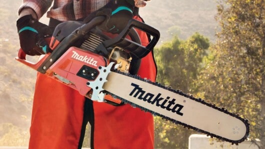 man holding makita chainsaw