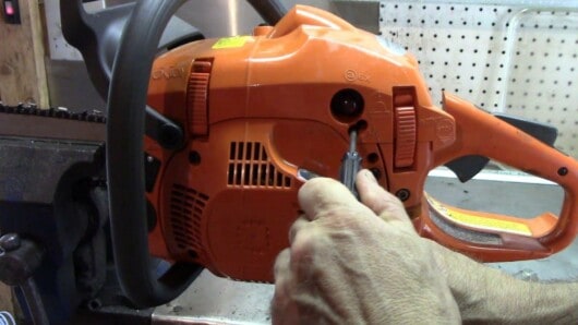 man tuning a chainsaw